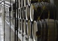 Through the wrought-iron metal gate you can see the wine cellar with old oak barrels lying in a row Royalty Free Stock Photo