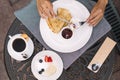 Graceful hands of caucasian girl spread jam on a pancake. Royalty Free Stock Photo