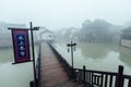 WUZHEN,CHINA-MARCH 6,2012: Ancient bridge over the canal . Morning fog over the city Royalty Free Stock Photo