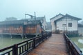 WUZHEN,CHINA-MARCH 6,2012: Ancient bridge over the canal . Morning fog over the city Royalty Free Stock Photo