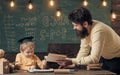 Wunderkind and genius concept. Father, teacher reading book, teaching kid, son, chalkboard on background. Boy child in