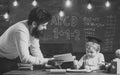 Wunderkind and genius concept. Father, teacher reading book, teaching kid, son, chalkboard on background. Boy child in