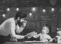Wunderkind and genius concept. Father, teacher reading book, teaching kid, son, chalkboard on background. Dad wants to
