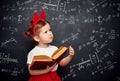 Wunderkind little girl schoolgirl with a book from the blackboar Royalty Free Stock Photo