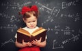 Wunderkind little girl schoolgirl with a book from the blackboar Royalty Free Stock Photo