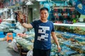 Chinese man demonstrates a lobster at a bazaar