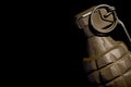 WW2 hand grenade against a black background.