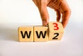 WW3 world war 3 symbol. Businessman turns the wooden cube and changes the concept word WW2 to WW3. Beautiful white table white Royalty Free Stock Photo