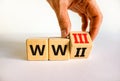 WW3 world war 3 symbol. Businessman turns the wooden cube and changes the concept word WW2 to WW3. Beautiful white table white