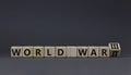 WW3 world war 3 symbol. Turned the wooden cube and changed the concept word World War 2 to World War 3. Beautiful grey table grey