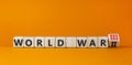 WW3 world war 3 symbol. Turned the wooden cube and changed the concept word World War 2 to World War 3. Beautiful orange table