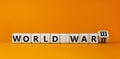 WW3 world war 3 symbol. Turned the wooden cube and changed the concept word World War 2 to World War 3. Beautiful orange table