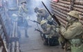 WWI British Army soldiers stand ready under poison gas attack while one sounds the alarm Royalty Free Stock Photo