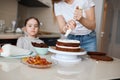 Wwoman hands squeezes cream on cake Royalty Free Stock Photo