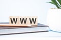 www acronym on building blocks supported by two different size pencils. Copy space Royalty Free Stock Photo