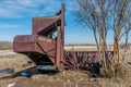 Wymark, SK, Canada- March 30, 2020: Vintage Massey-Harris pull-type combine abandoned in a Saskatchewan, Canada field