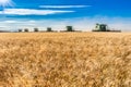 Wymark, SK- Sept 8, 2020: Multiple combines harvesting wheat in a field at sunset in Wymark, Saskatchewan