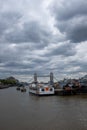 The Wyndham boat docked in the river themes, London bridge in sight. Spectacular cloudy sky above.