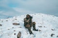 Hunter male uses binoculars and a spotting scope to look for deer on a hunting trip, sitting in