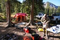 Wyoming, USA - September 30 Hunter wearing camo sets up a deer campsite for hunting. Tent and pickup truck with gear in