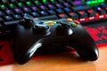 X Box 360 controller in front of a RGB gaming keyboard.