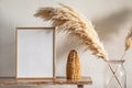 30x40 cm photo frame on a bench with pampas grass near the wall