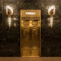 1x1 crop of elevator in vintage art deco building with marble walls and golden sconces