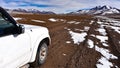 A 4x4 expedition vehicle passes through the surreal winter landscapes and snow capped mountain scenery in the SIloli Desert, Sud