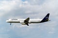 "Lufthansa " commercial passenger airplane soaring through a cloudy sky