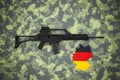 German 5.56 x 45mm assault rifleon camouflage background