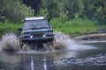 4x4 off-road car crosses a water barrier with splashes at high speed. Royalty Free Stock Photo