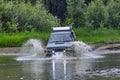 4x4 off-road car crosses a water barrier with splashes at high speed. Royalty Free Stock Photo