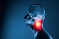 X-ray of a man's head on blue background. The neck spine is highlighted by yellow red colour. Royalty Free Stock Photo