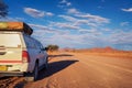 4x4 rental car equipped with a roof tent parks on a dirt road in Namibia