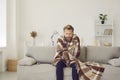 Man freezing and shivering in his cold house in winter because of broken thermostat Royalty Free Stock Photo