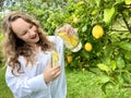 it& x27;s just a lemon paradise, a teenage girl stands against the backdrop of a lemon tree with lemons and drinks Royalty Free Stock Photo