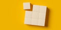 3x3 square array of empty, blank wood blocks or cubes with one detached on yellow background, business concept template with copy