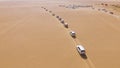 4x4 SUVs cars driving through the sand dunes in the desert of Abu Dhabi. Stock. Top view on SUVs in the desert