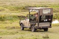 4x4 vehicle on african safari game drive with tourists watching wild animals