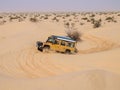 4X4 vehicle drives around the sand dunes of the Sahara Desert. Royalty Free Stock Photo