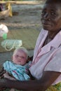 Focus on blue eyed albino baby girl being held by older woman