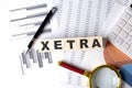 XETRA text on wooden block on a graph background with pen and magnifier Royalty Free Stock Photo