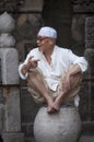 Portrait of a man wearing a taqiyah sitting at a stone, at the Xian Great Mosque in the city of Xian in China