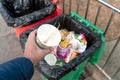 Xian, China - December 29, 2019: Chinese hand people holding waste food with black general garbage waste food and drink containers