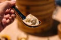 Xiao Long Bao Soup Dumpling in spoon with blur bamboo streamer basket in background