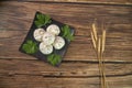 Xiaolongbao Chinese steamed bun on black plate, wheat ears, top view, old wood background Royalty Free Stock Photo