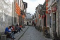 Xidi Ancient Town in Anhui Province, China. Local people sit as tourists explore the historic town