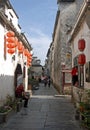 Xidi Ancient Town in Anhui Province, China. A storekeeper waits as tourists explore the historic town