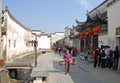 Xidi Ancient Town in Anhui Province, China. An old woman carries two baskets