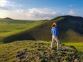 Xilinhot - A man standing on a green hill in Xilinhot, Inner Mongolia and enjoys a sunset. He is wearing a cowboy hat. Royalty Free Stock Photo